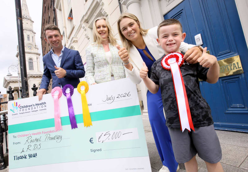 Rachel Proudley presents a €5,000 cheque to Children's Health Foundation with RDS representatives and a young boy outside Temple Street Hospital.