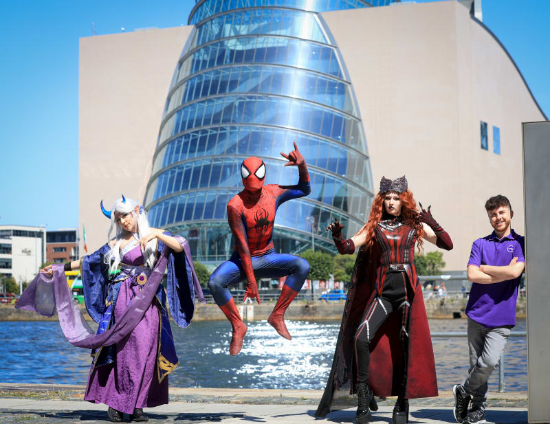 Cosplayers dressed as Spider-Man, an anime character, and Scarlet Witch pose outside Dublin Convention Centre.