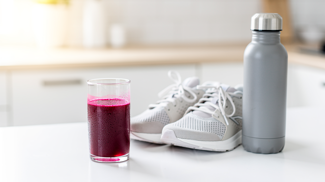 Färska rödbetor och ett glas rödbetsjuice på en träskärbräda