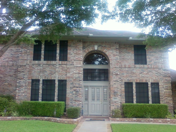 Red brick home after solar screens