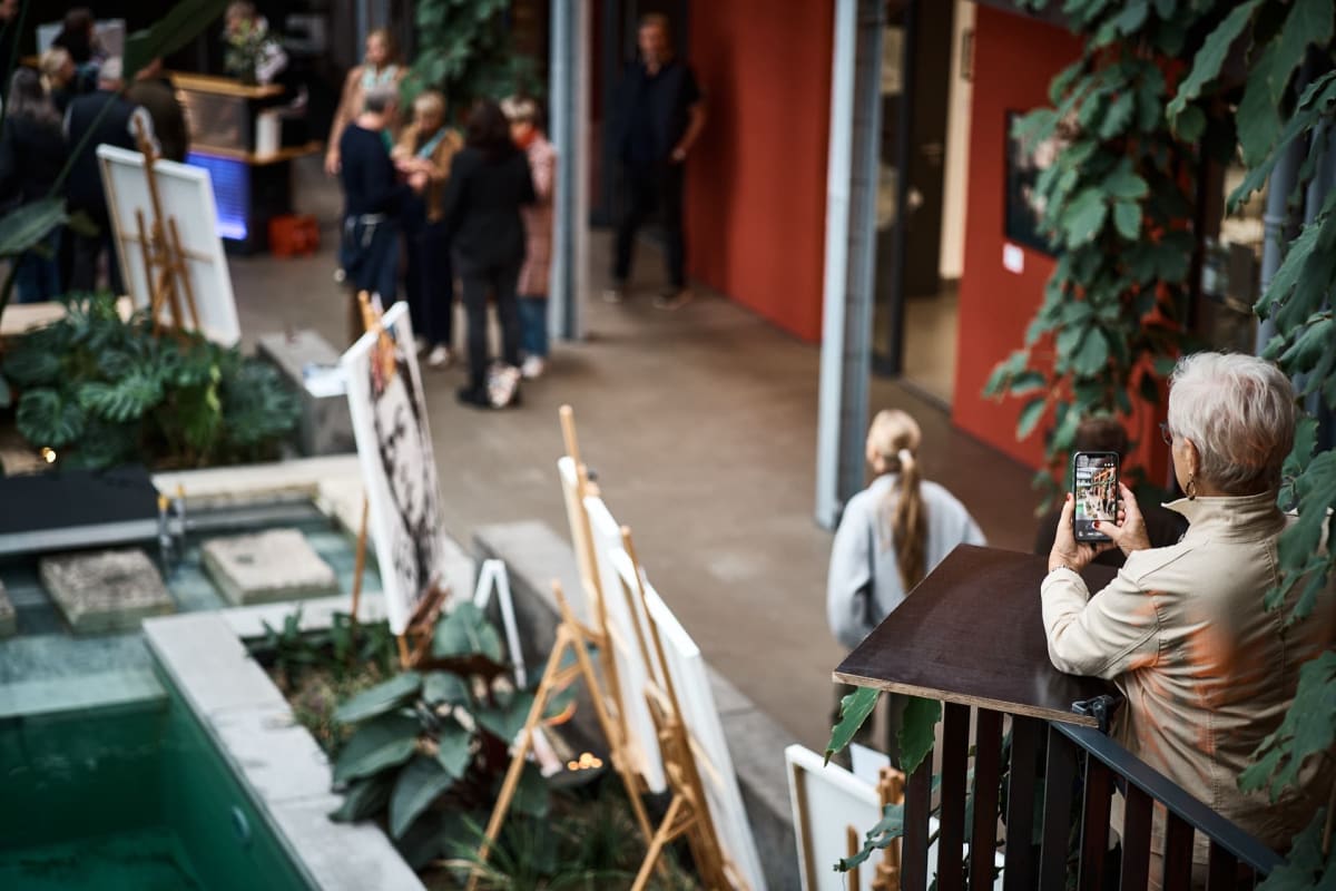 Gast fotografiert die Ausstellung von der Galerie, artmosphere Vol 2 im Innergarden Schutterwald