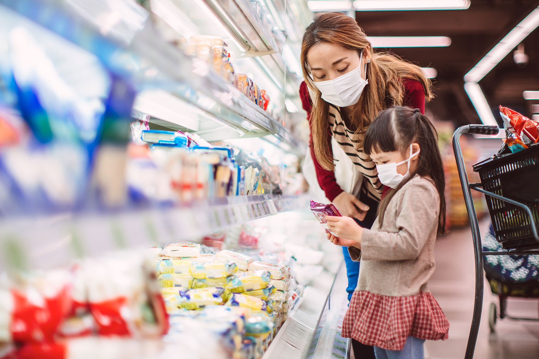 Mother and child in the frozen food section of a grocery store