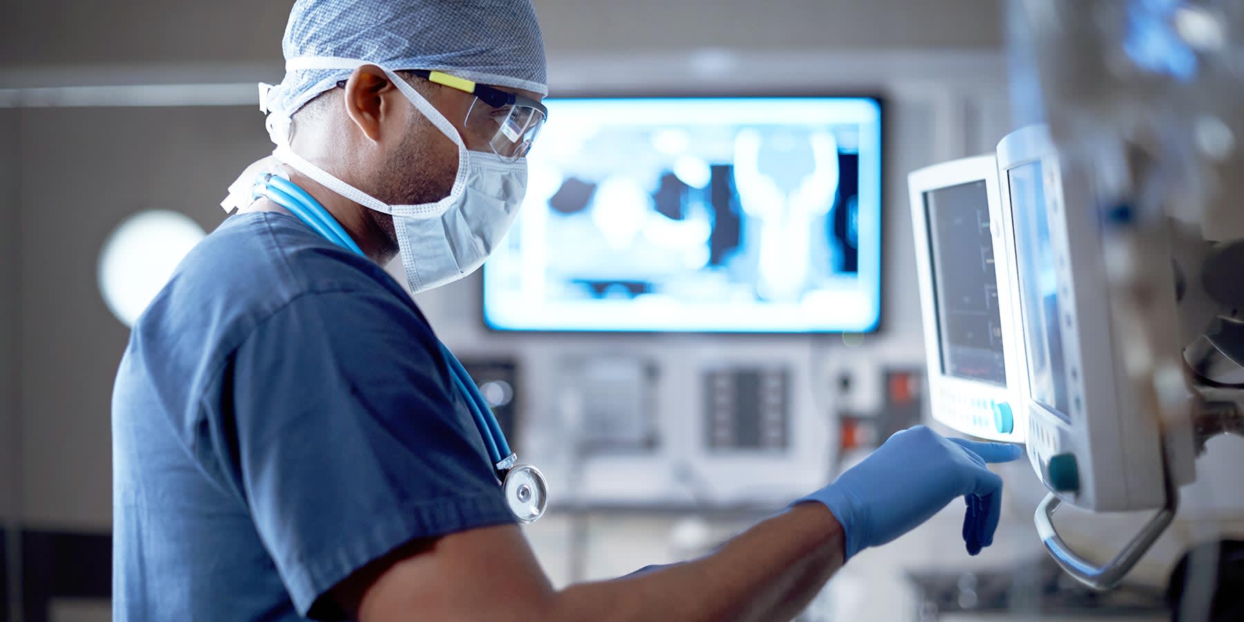 Medical personnel in front of a screen with personal protective equipment on