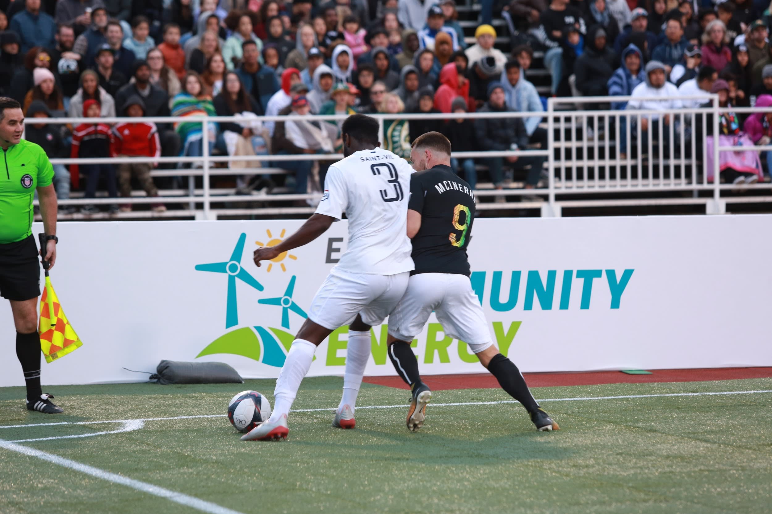 Oakland Roots playing soccer in front of EBCE signage