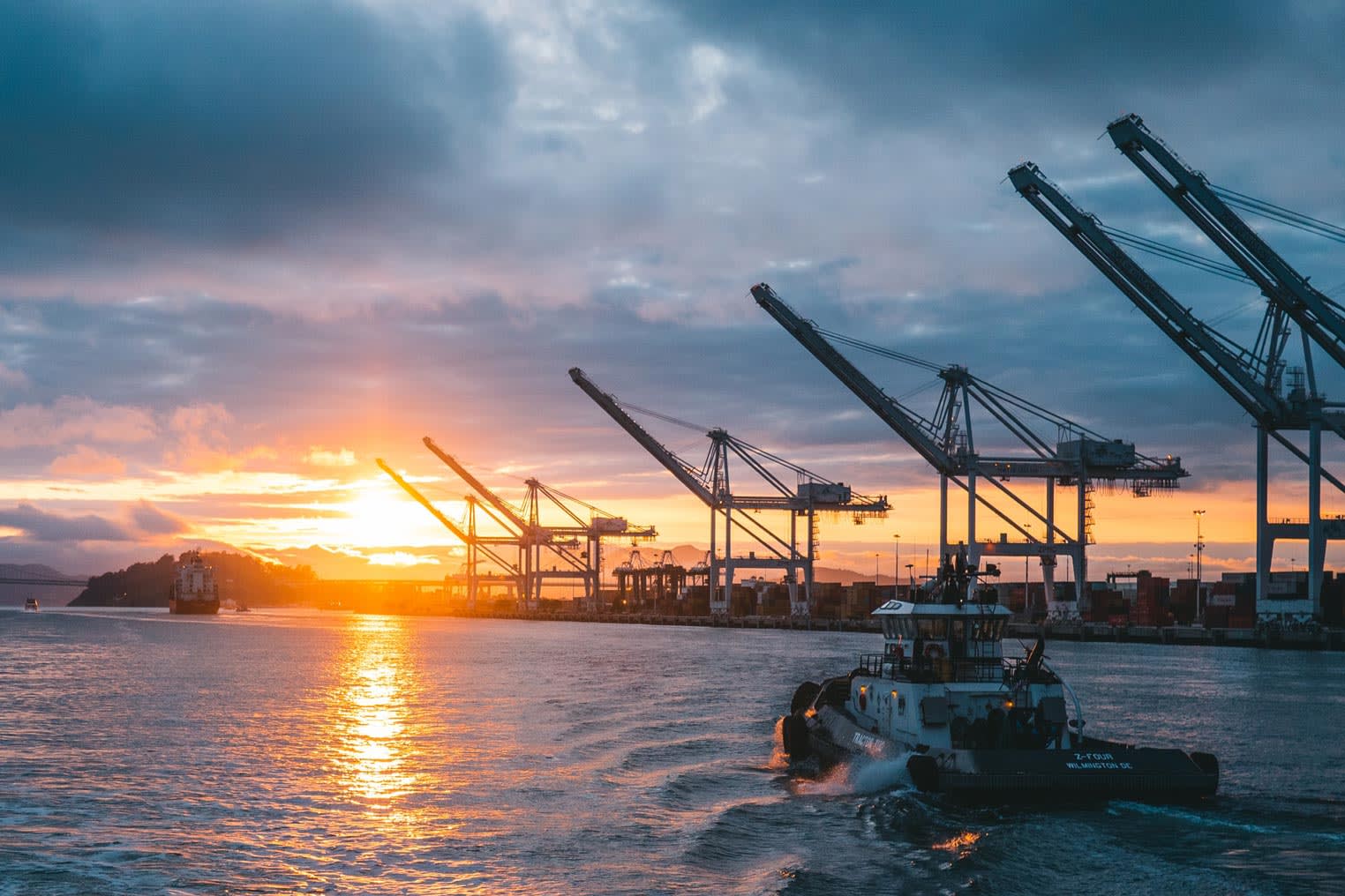 View of Port Of Oakland with a ship going out, at susnet