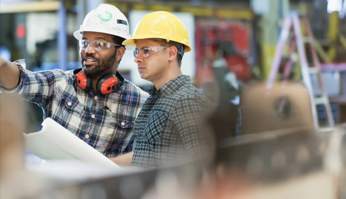 Two men In a hard hats discussing plans