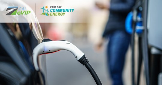 Vehicle at charging station with closeup of EV charging connector