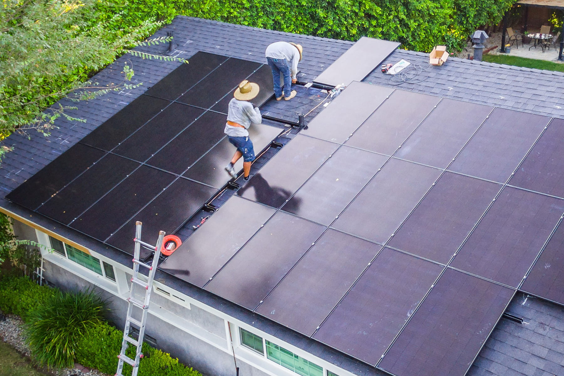 Revalue.io workers installing solar panels on a roof