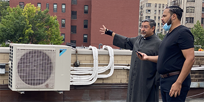 Priest and man preforming energy assessment on rooftop