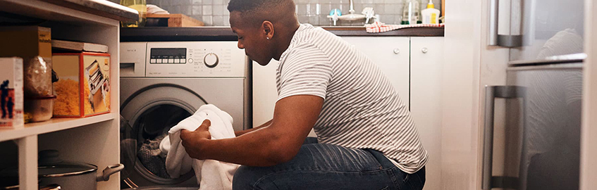 Man folding laundry in kitchen