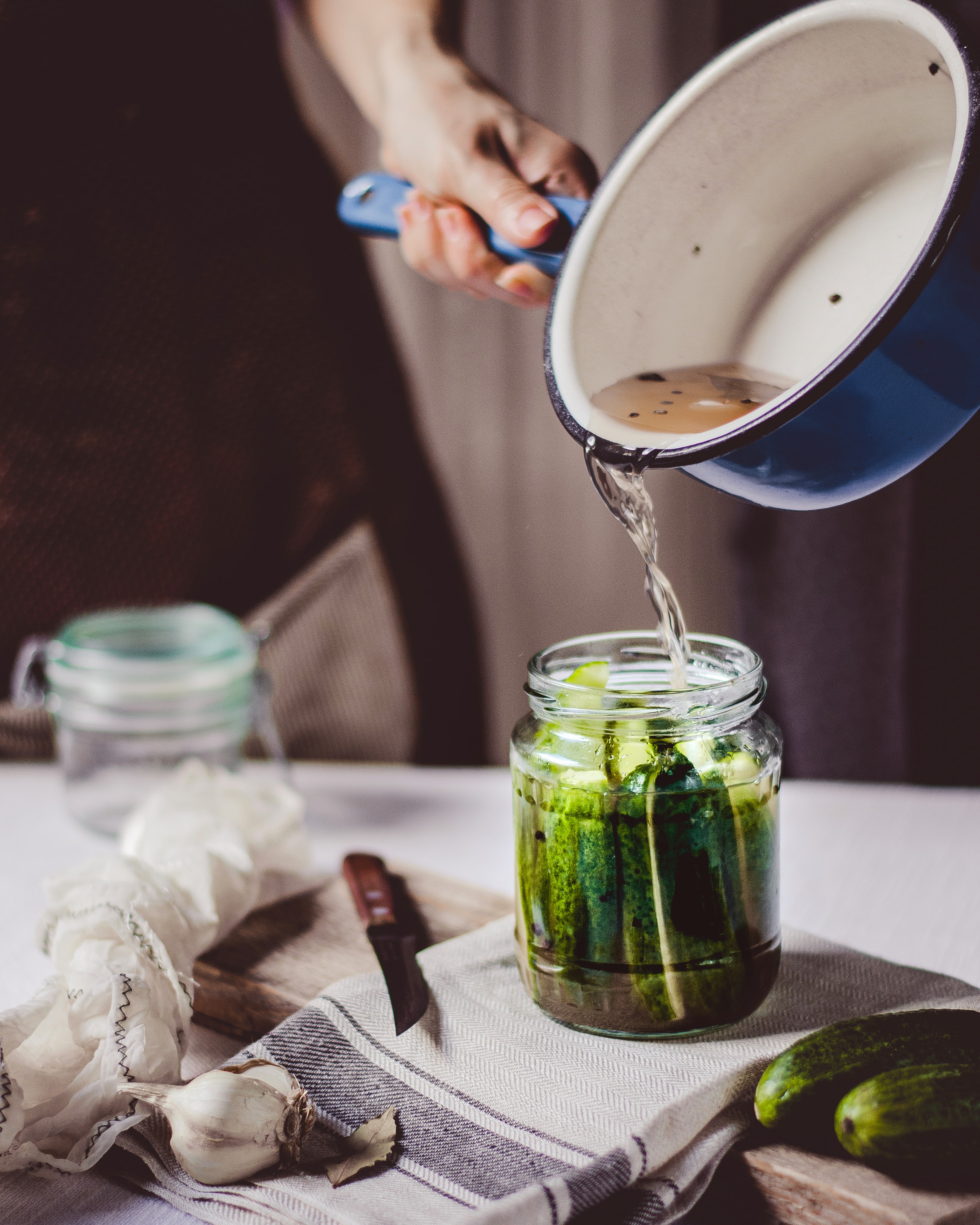Sliced cucumbers covered with brine in a jar