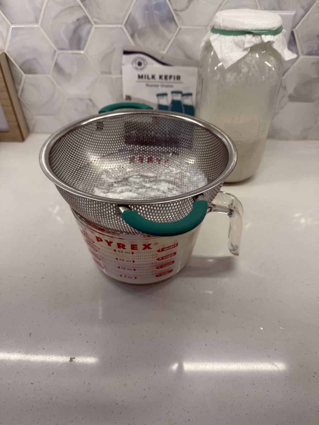 Straining the kefir for bottling and refrigerating.