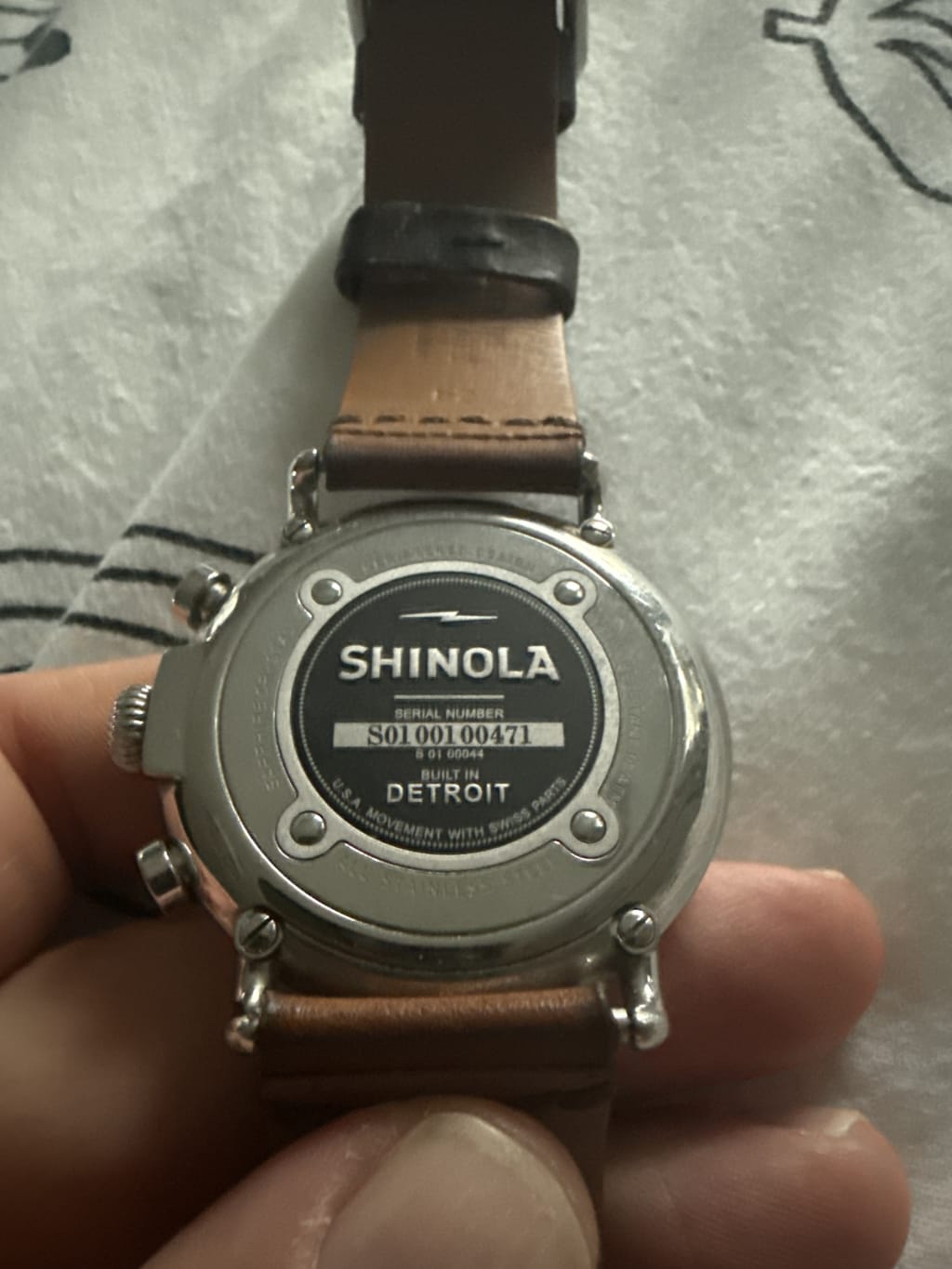 Back of a Shinola watch with a leather strap, showing the serial number and "Built in Detroit."
