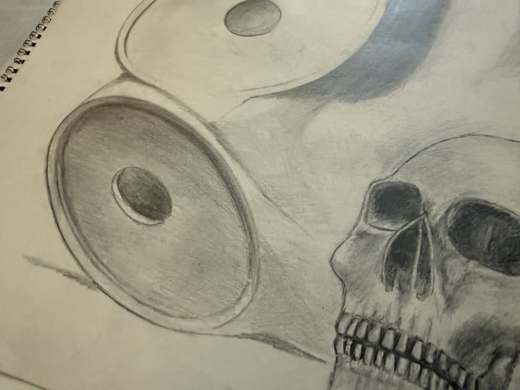 Sketch of a skull alongside a large pencil drawing of mannequin on the side. 