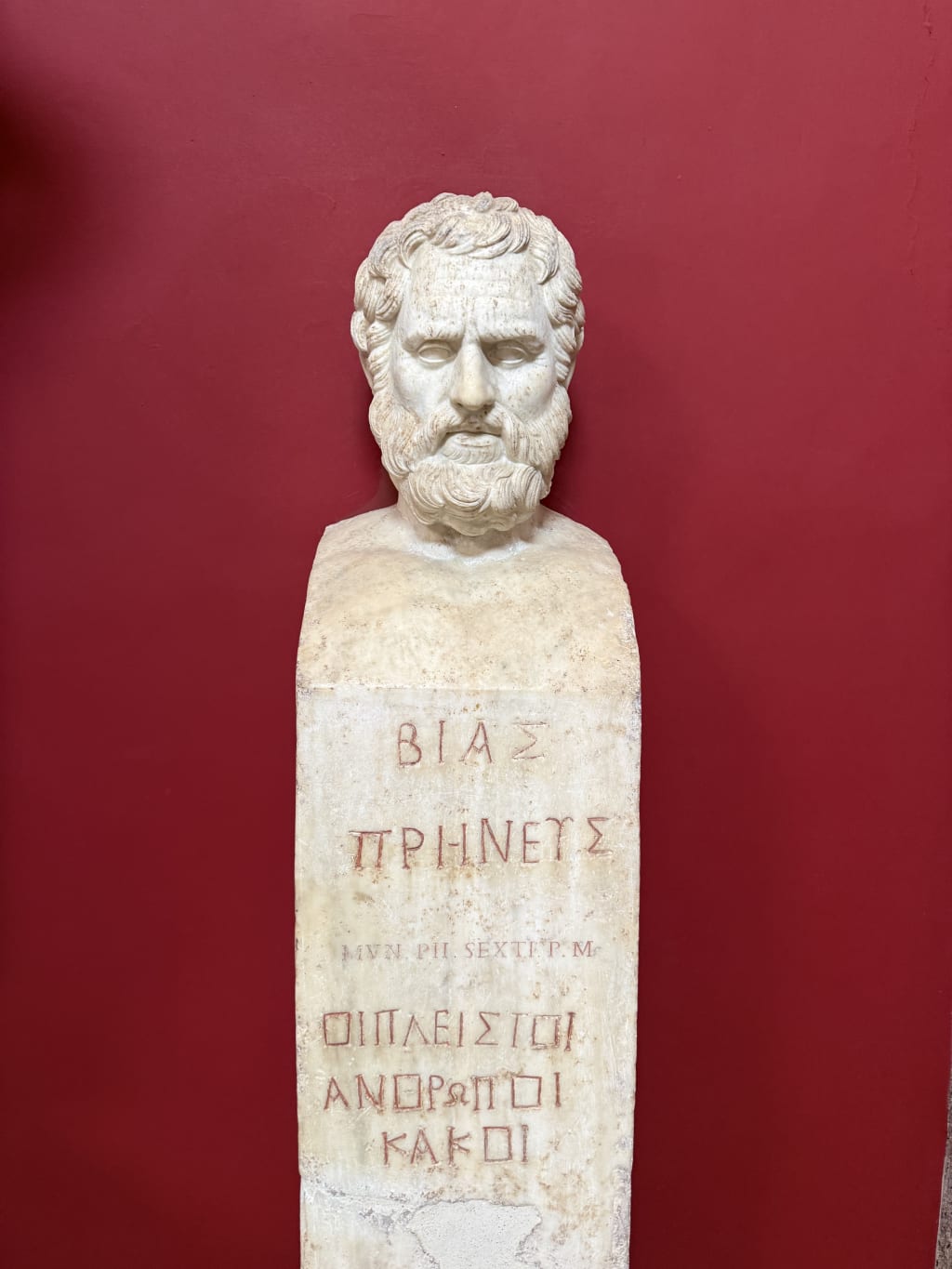 Marble bust of a bearded man with ancient Greek and Latin inscriptions on the pedestal.