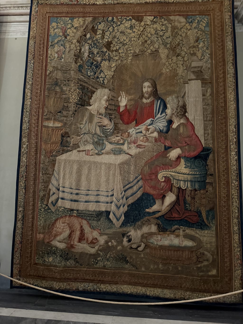 A detailed tapestry Jesus having dinner with two disciples on the road to Emmaus.