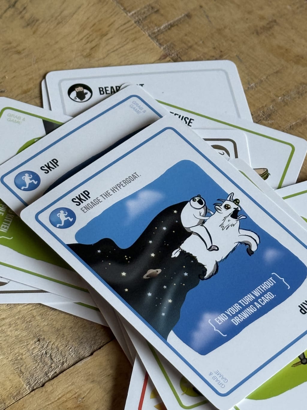 A stack of colorful game cards, including a blue "Skip" card with a panda riding a goat.