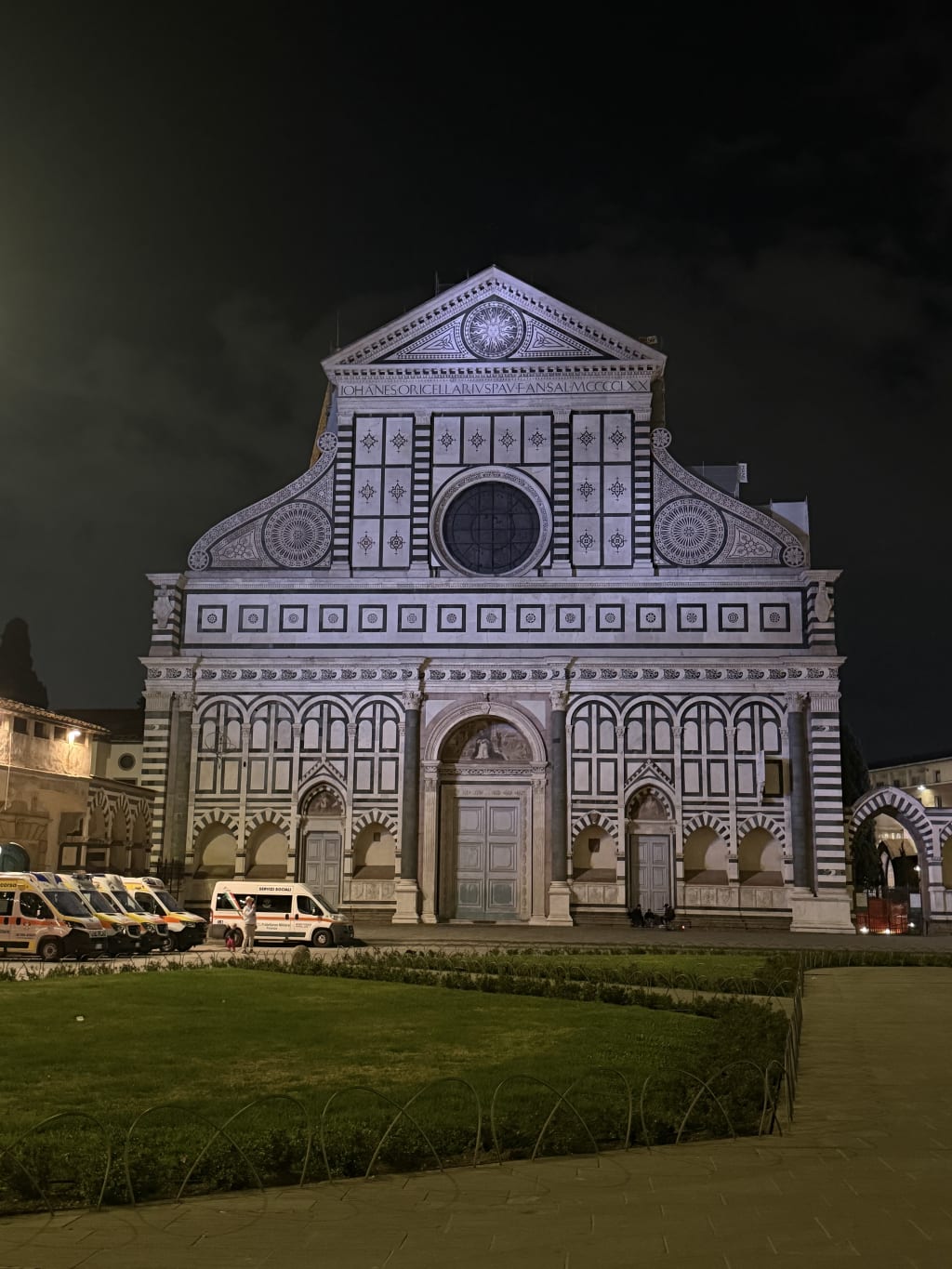 The night view of Basilica di Santa Maria Novella with parked ambulances in Florence.
