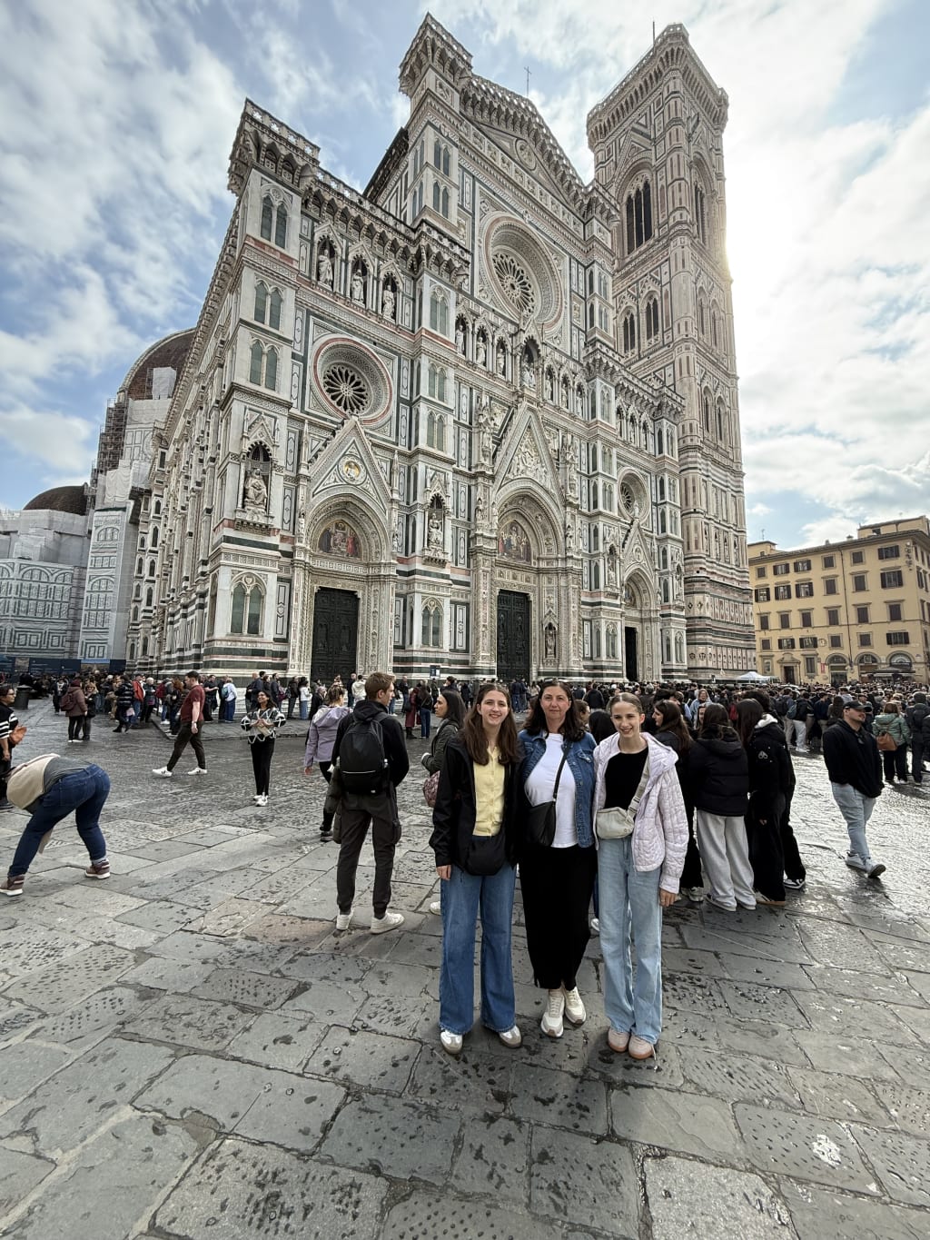 Sofia, Anca and Maia posing in front of the historic Florence Cathedral in Italy on a cloudy day.