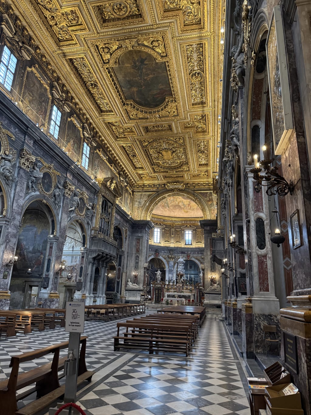 Interior view of a grand ornate church with golden ceiling and marble columns.