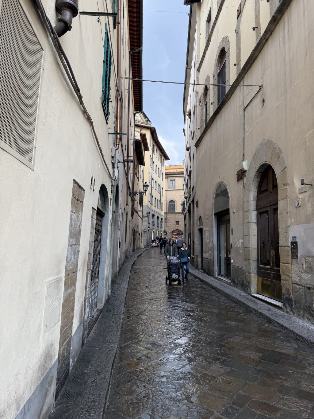 The rain made the cobblestone shiny and now the whole street has a new feel.