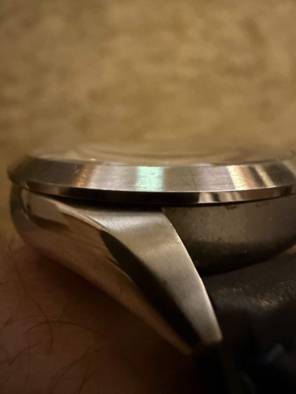 Close-up of a stainless steel watch case with visible polishing and brushed texture.