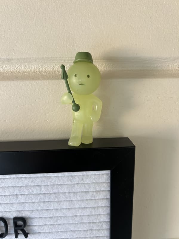 Green smiski holding baton