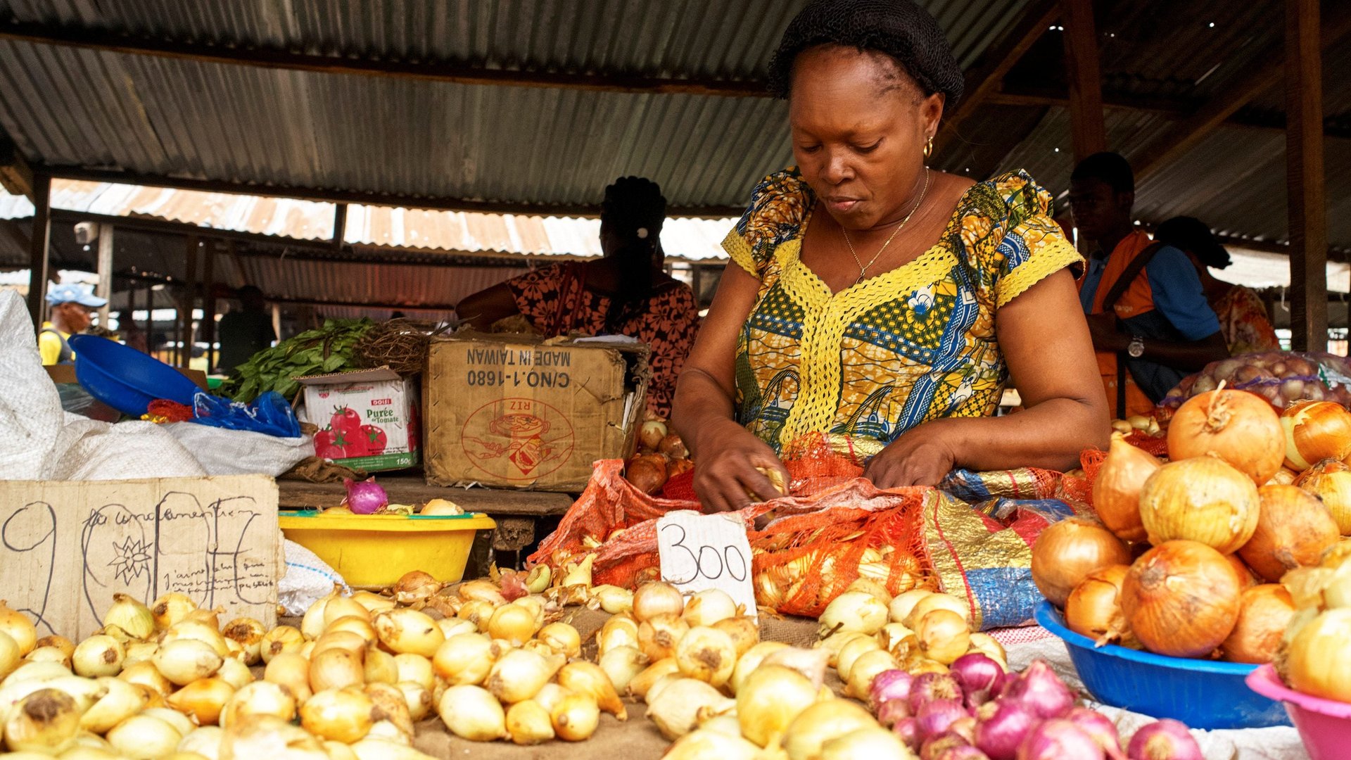 Vendeuse d'oignons au marché de Kinshasa, économie informelle RDC