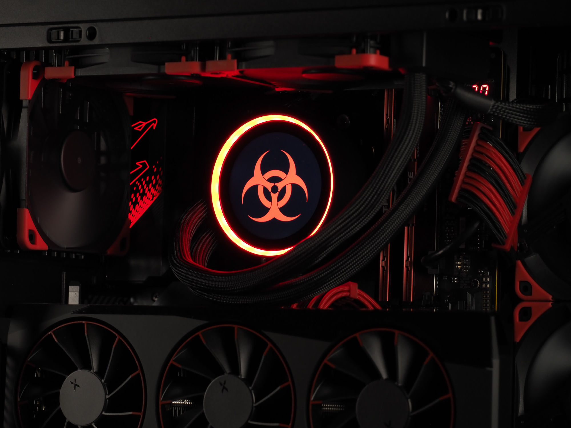 The NZXT cooler biohazard face glowing red-orange against the black interior