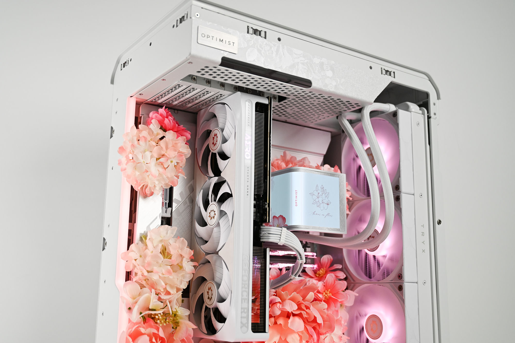 Pink peony and hydrangea blooms pressed right up against the GeForce RTX card on the front of the build