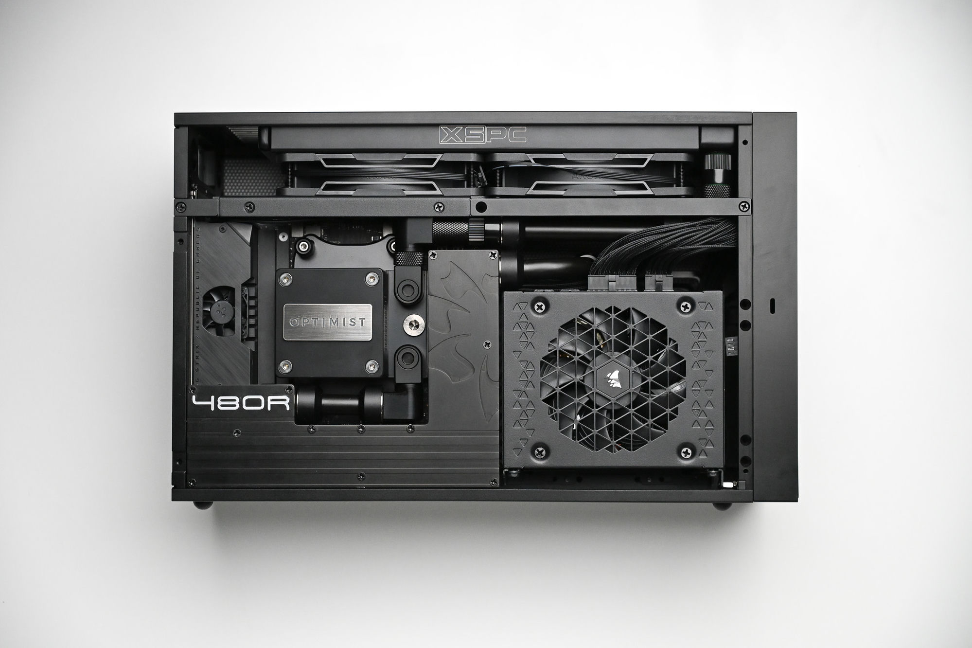 Top-down view of the 480R platform build — Optimist block, XSPC radiator, dual Noctua fans and Corsair supply in a blackout chassis