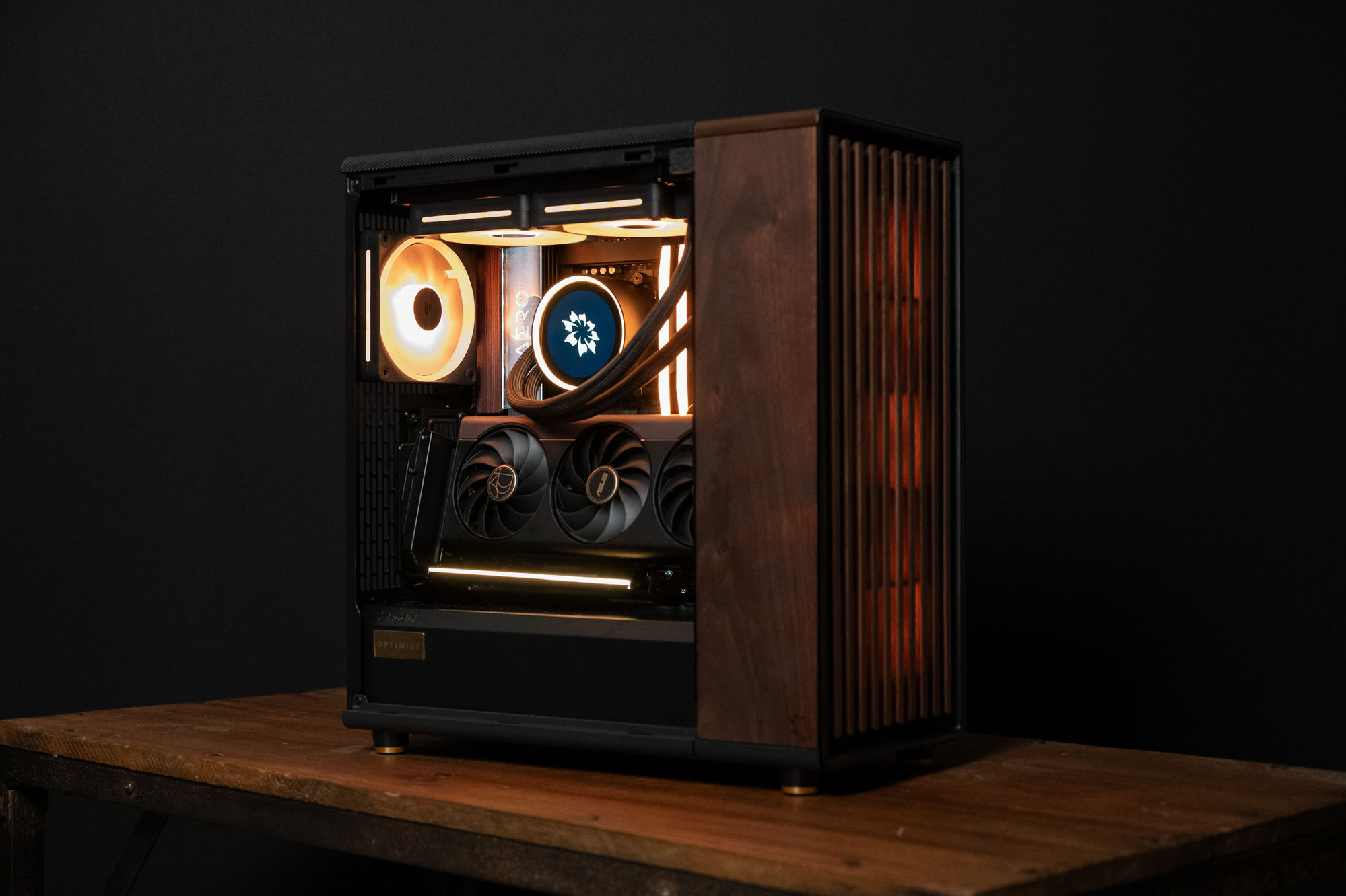 The 2026 Nocturne — a warm-lit AERO build with a solid hardwood side panel, on a leather-topped desk in a study