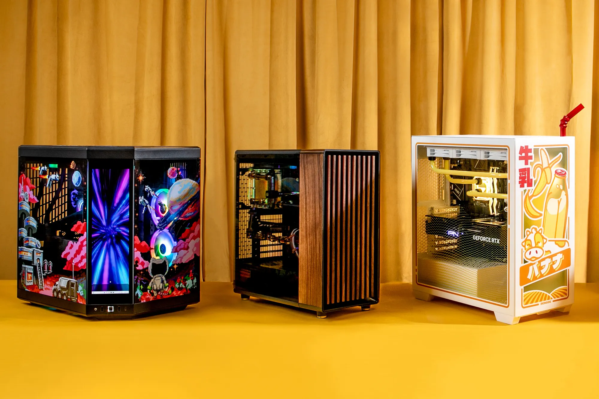 Three custom PCs photographed for Bloomberg Businessweek against a yellow studio backdrop — an Optimist wood-panelled Nocturne at center, between two other builds.