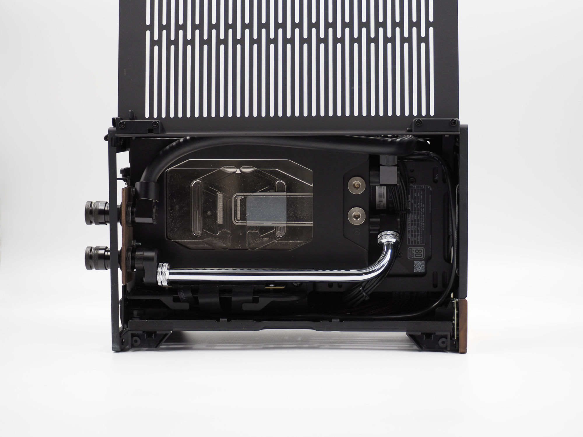 The compact Optimist SFF unit, its water block and reservoir visible through a vented panel, quick-disconnect couplers on the loop