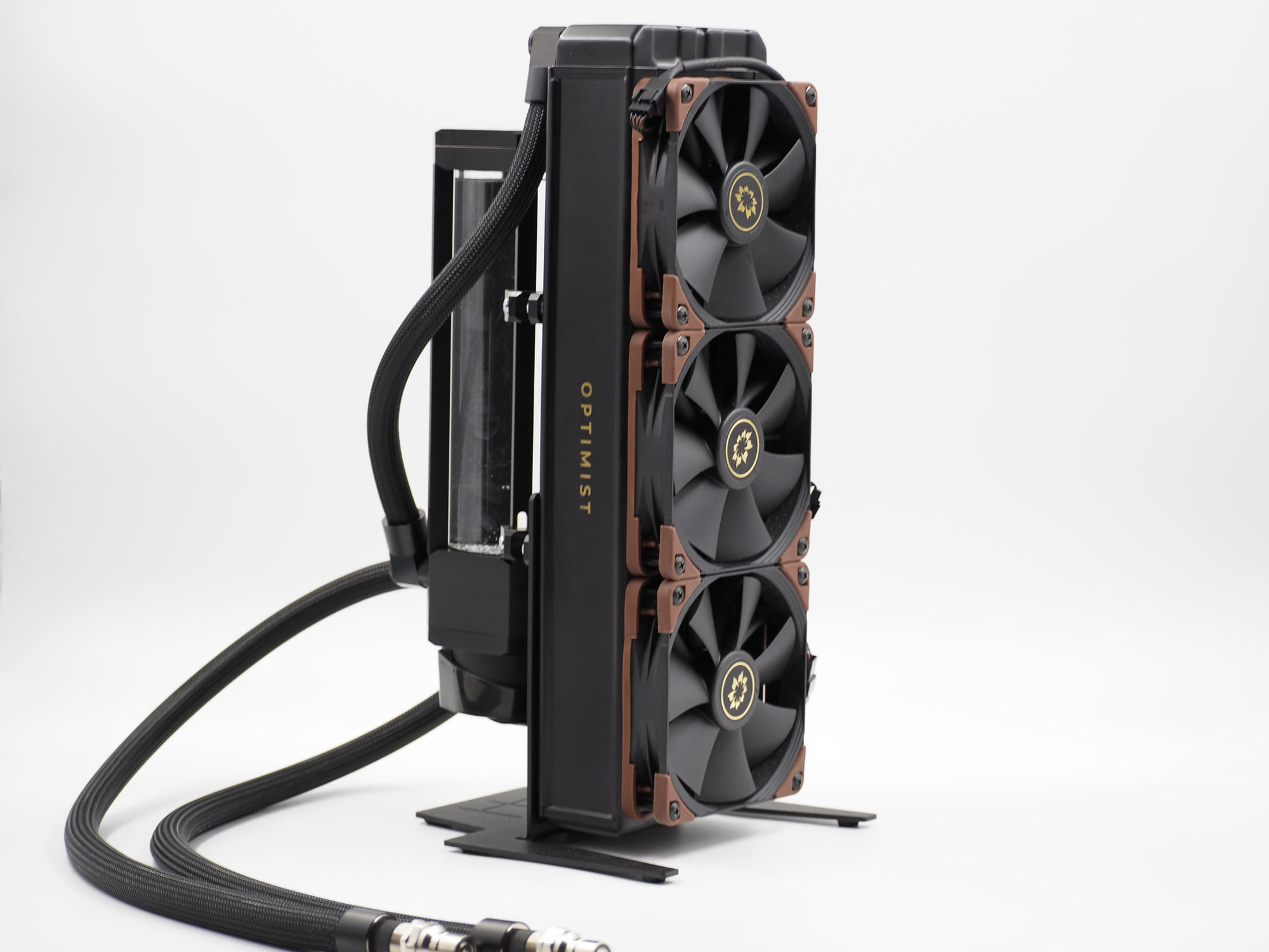 The Optimist external radiator tower, front on — three fans with gold flower-emblem hubs and “OPTIMIST” lettering down the side, on its own stand