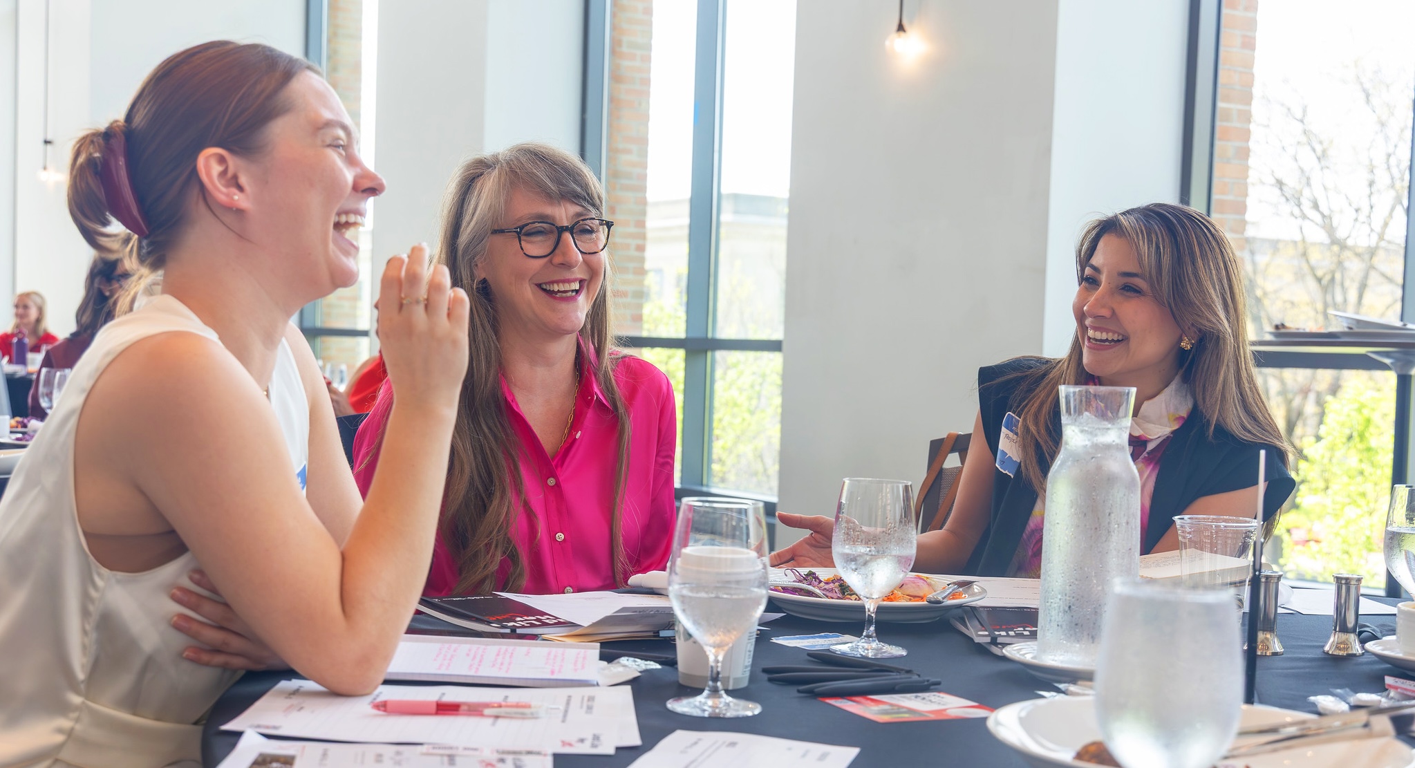 Attendees laughing and connecting at a hosted table