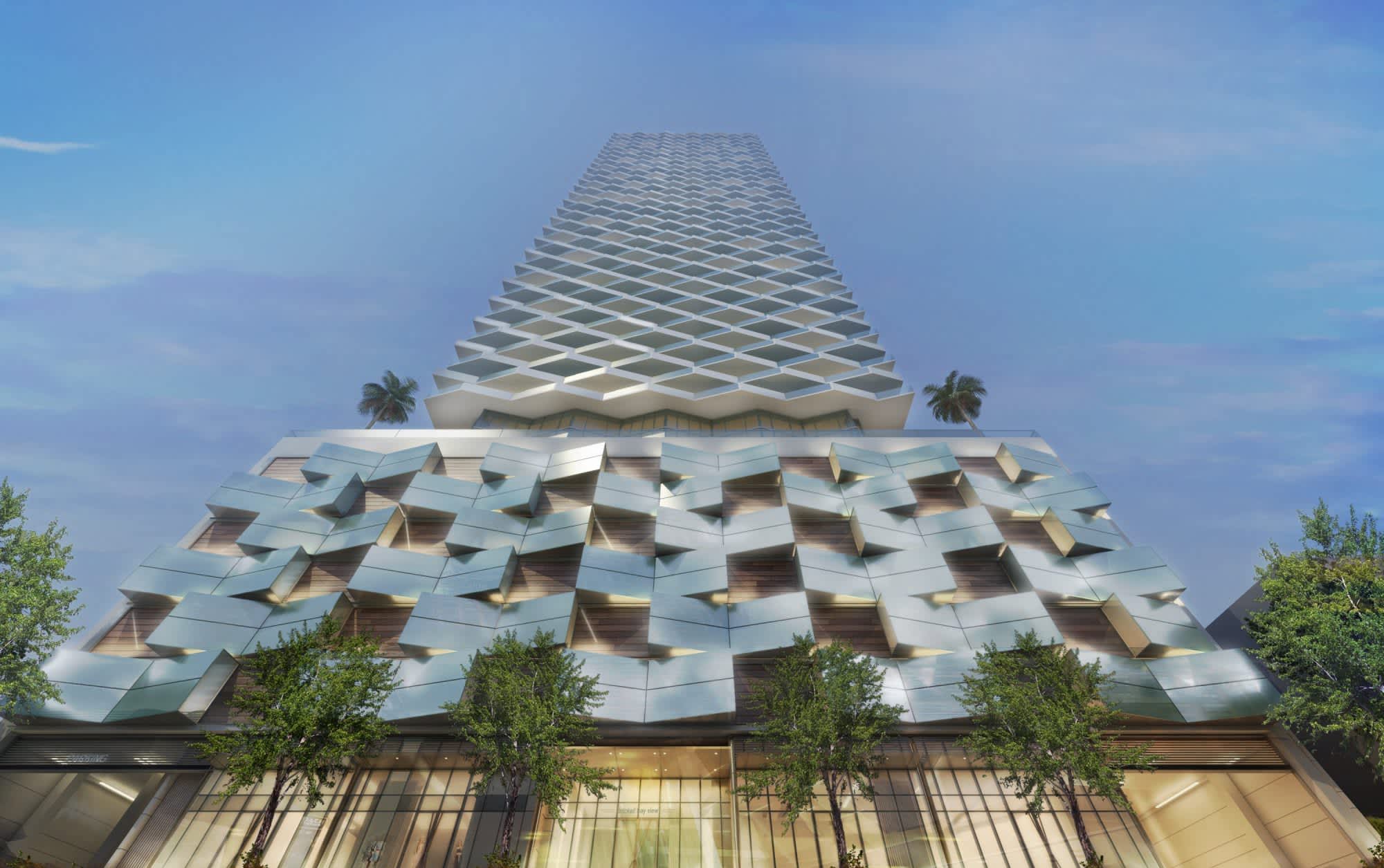 Modern high-rise residential tower with geometric stacked balconies, palm trees, and green landscaping at street level.