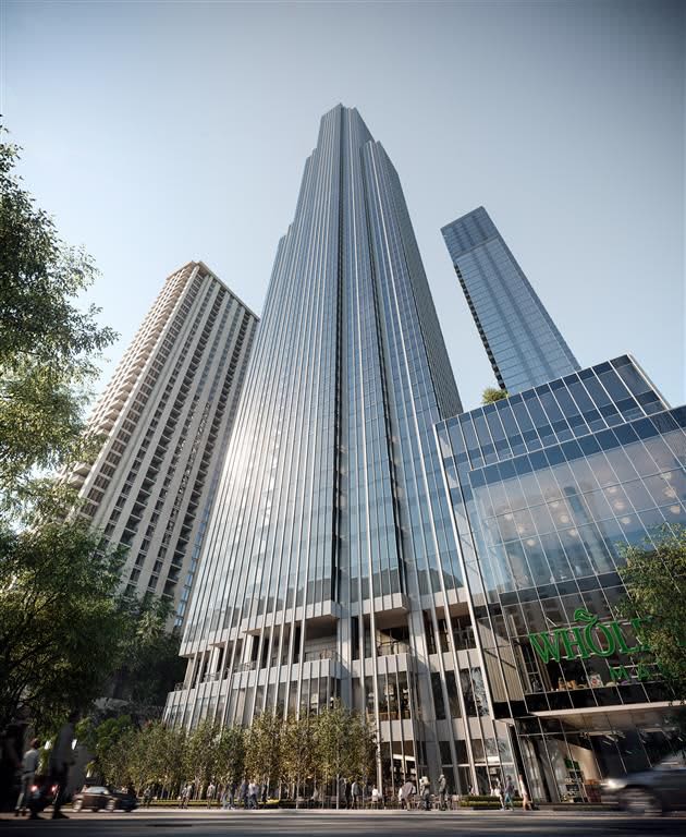 Tall ribbed metal and glass skyscraper with street-level entrance, flanked by other high-rises and green trees.