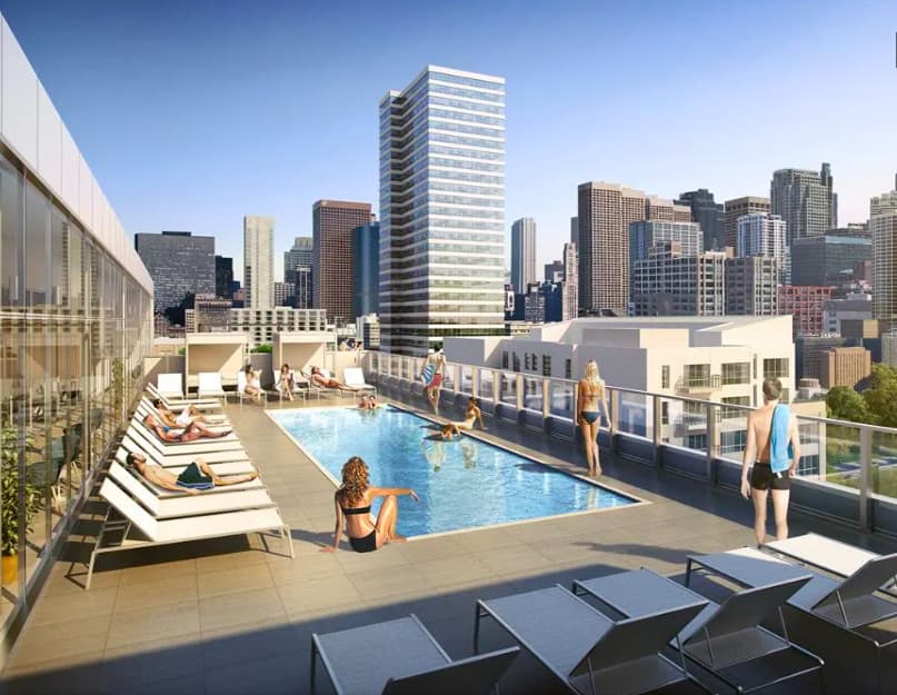 Rooftop pool deck with lounge chairs, swimming pool, and Chicago skyline backdrop.