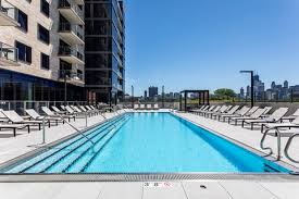 Olympic-length swimming pool with lap lanes, lounge chairs, and Chicago skyline in background.