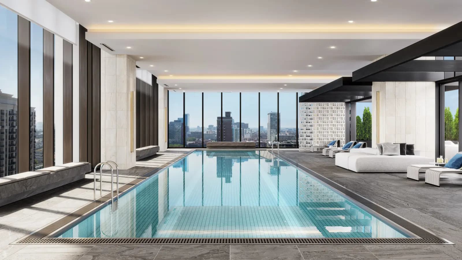 Indoor lap pool with teal tile, metal ladder, and floor-to-ceiling windows showing Chicago skyline and lounge seating area.