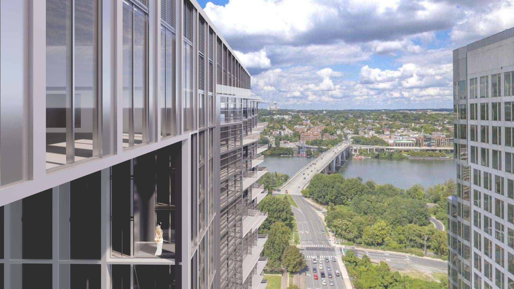 High-rise apartment balcony overlooking Potomac River, tree-lined neighborhoods, and Arlington cityscape under blue sky.