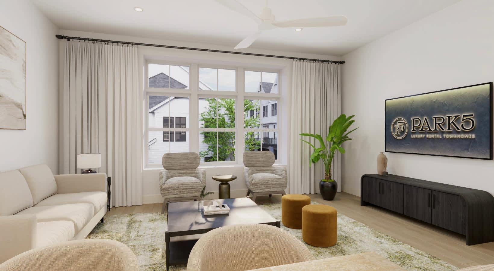 Living room with cream-colored sofa and accent chairs, large multi-pane windows with sheer curtains, black TV console, and mustard-yellow ottomans on patterned area rug.