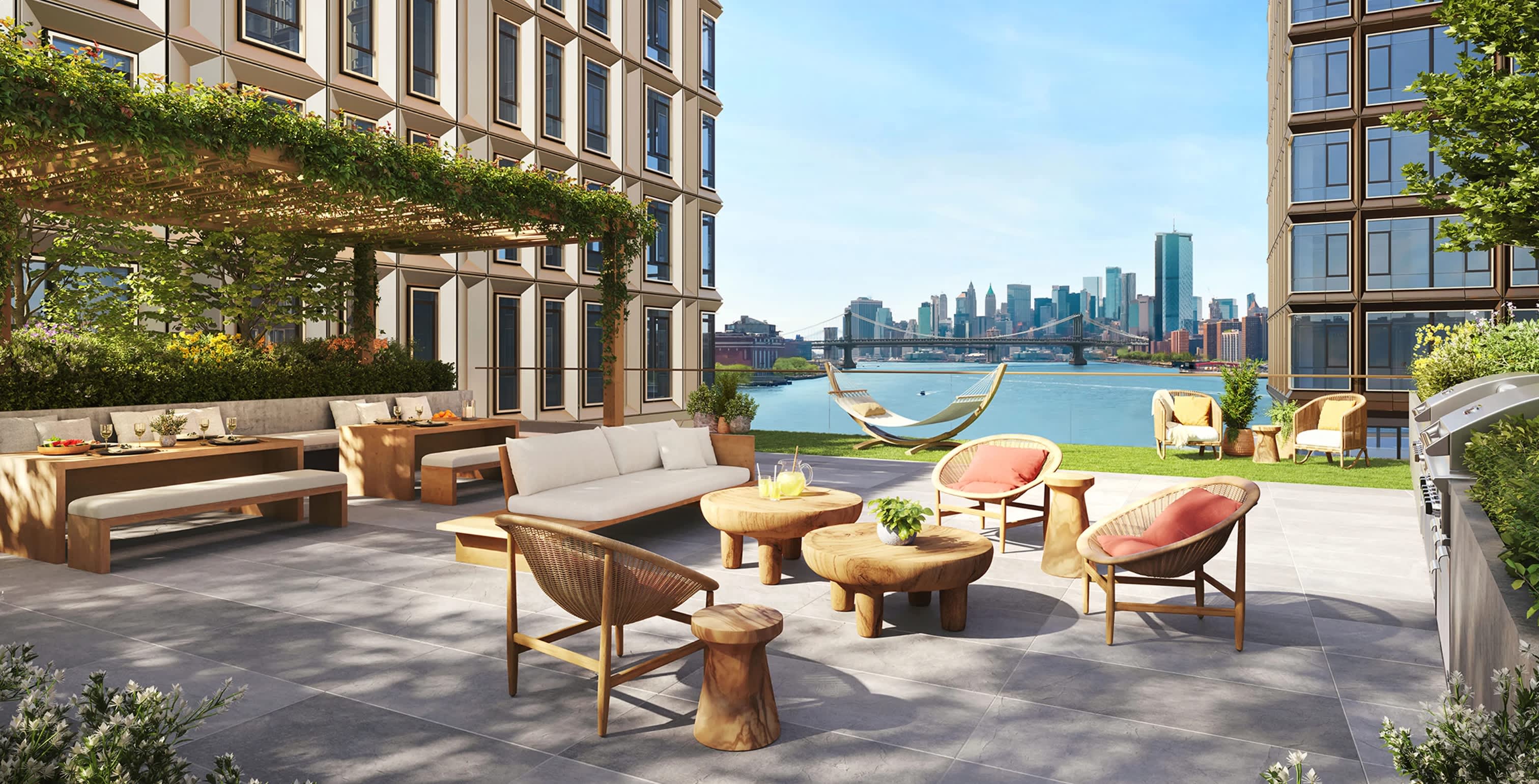 Rooftop terrace with wooden lounge chairs, sofas, and hammock overlooking East River and Manhattan skyline.