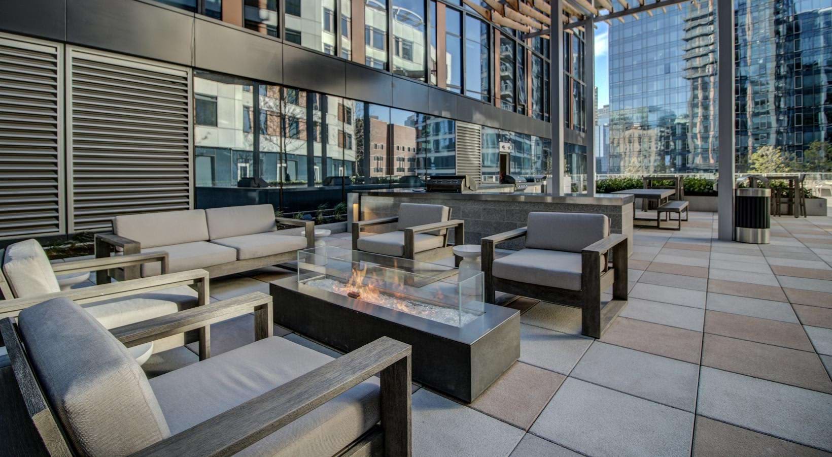 Rooftop terrace with contemporary lounge seating, gas fireplace, and downtown Boston skyline views.