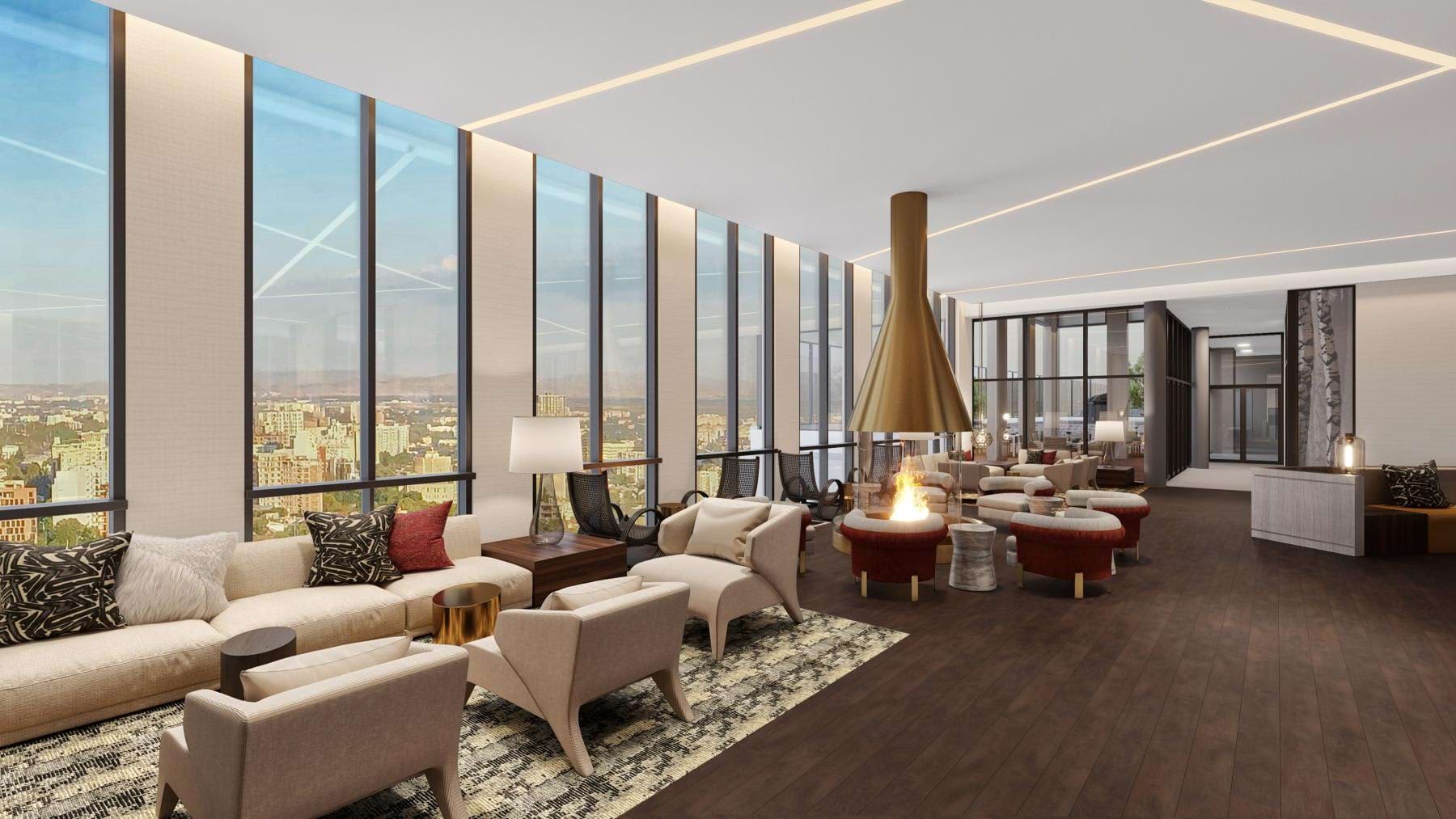 High-rise living room with cream seating, dark wood flooring, brass fireplace, and expansive windows overlooking cityscape.