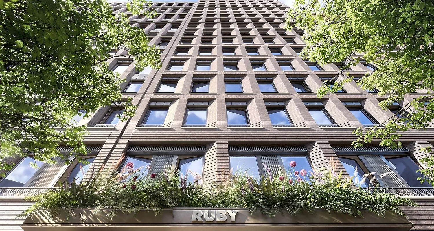 Tall residential building with regular grid of windows, green foliage on sides, and planted window boxes at street level with Ruby signage.