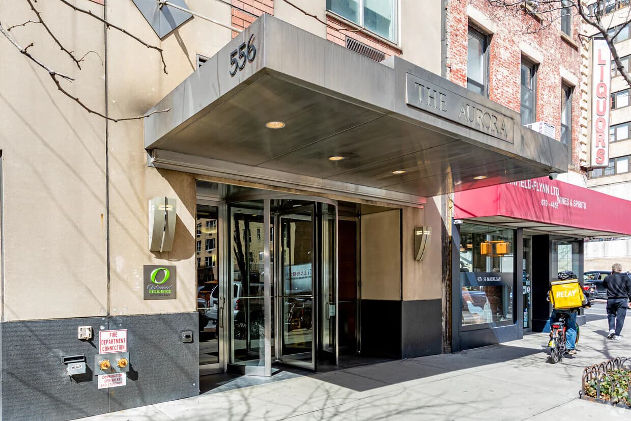 Building entrance at 556 3rd Ave with glass doors, metal canopy, and street-level storefront in New York.