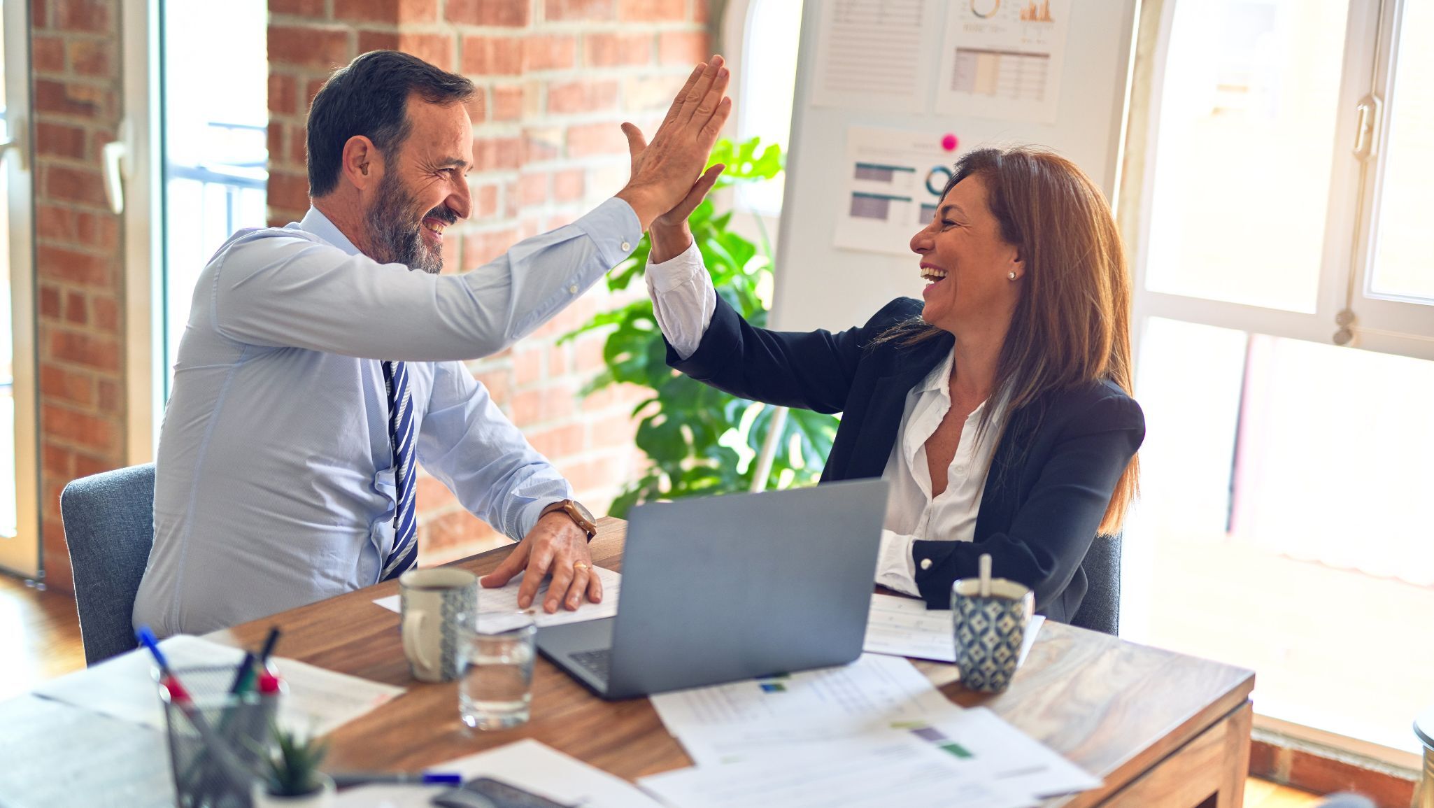 Two colleagues celebrating a business deal