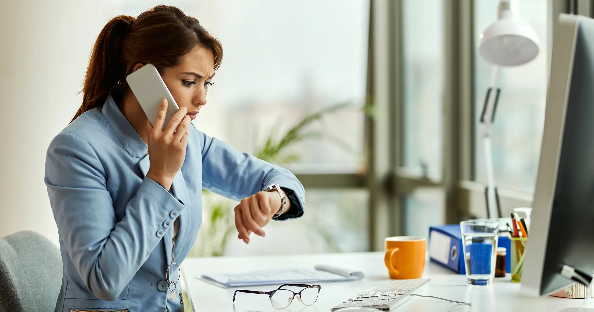 Businesswoman checking her watch as she makes a call